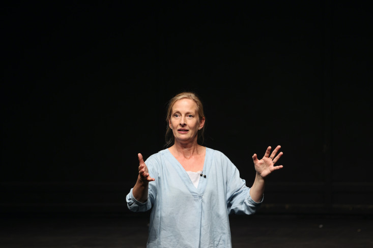 Ein Portrait der Schauspielerin. Sie steht mit erhobenen Händen da. Hinter ihr ist alles schwarz, ihre hellblaue Bluse hebt sich stark vom Hintergrund ab. Ein Portrait der Schauspielerin. Sie steht mit erhobenen Händen da. Hinter ihr ist alles schwarz, ihre hellblaue Bluse hebt sich stark vom Hintergrund ab.