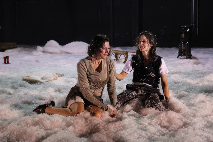 Zwei Schauspielerinnen sitzen nebeneinander im Schnee. Zwei Schauspielerinnen sitzen nebeneinander im Schnee.