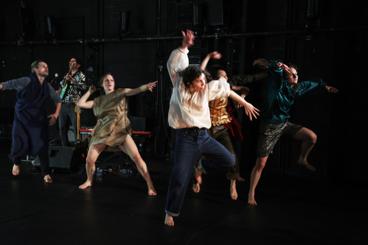 Vorn auf der Bühne tanzen fünf Personen. Hinten steht ein Musiker.  Vorn auf der Bühne tanzen fünf Personen. Hinten steht ein Musiker.