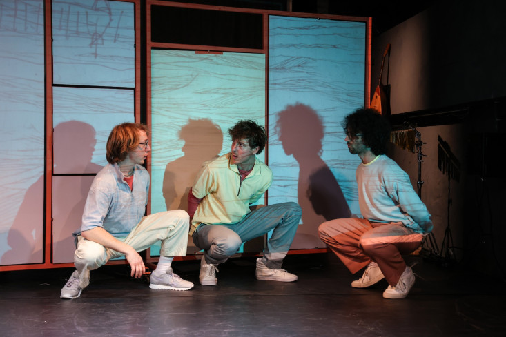 Drei Personen hocken nebeneinander. Sie sprechen miteinander. Drei Personen hocken nebeneinander. Sie sprechen miteinander.