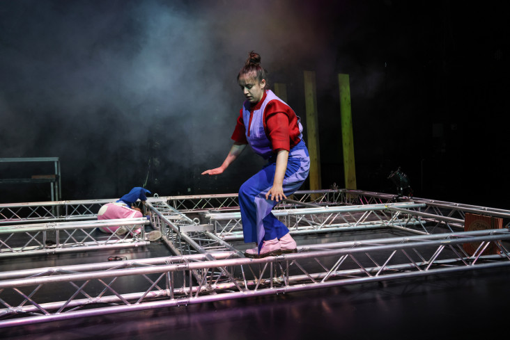 Eine Schauspielerin balanciert auf einem Gerüst. Eine Schauspielerin balanciert auf einem Gerüst.