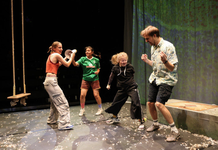 Vier Personen tanzen. Links hängt eine Schaukel. Vier Personen tanzen. Links hängt eine Schaukel.