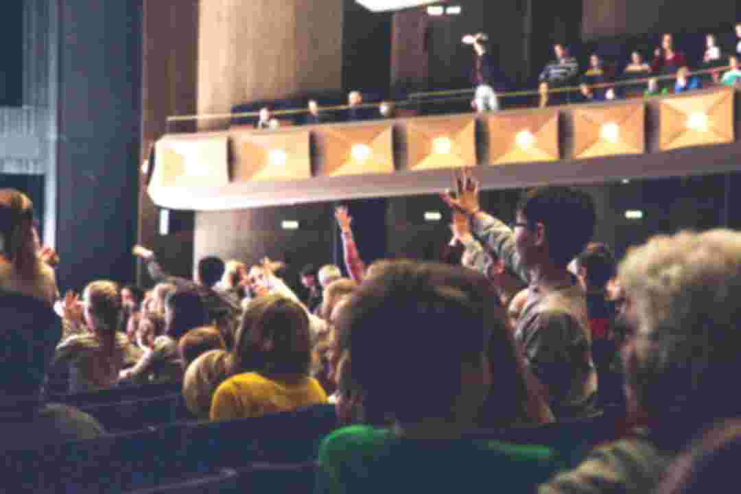 Im Opernhaus blicken Kinder in Richtung der Bühne und strecken ihre Hände in die Höhe. © Melina Rudolf