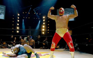 Im Ring mit Rossini  | Lesen Sie im Blog Kämpfer des Lucha Libre in einer Arena in Mexiko. Ein kostümierter und maskierter Kämpfer triumphiert mit großer Geste über seinen Kontrahenten, der am Boden liegt.