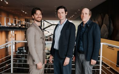 Musikalische Leitung ab 2026/27: Maxime Pascal, Michele Spotti, Titus Engel  | Lesen Sie die Pressemitteilung Unser neues Dirigententeam ab 26/27: von links nach rechts Michele Spotti und Maxime Pascal (Principal Guest Conductors) und Titus Engel (Conductor in Residence). Sie stehen auf einer der Freitreppen im Foyer.