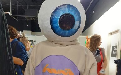 Rieseninteresse an unseren Kostümen!  | Alle Infos Ein Besucher des Kostümverkaufs mit einem Auge auf dem Kopf.